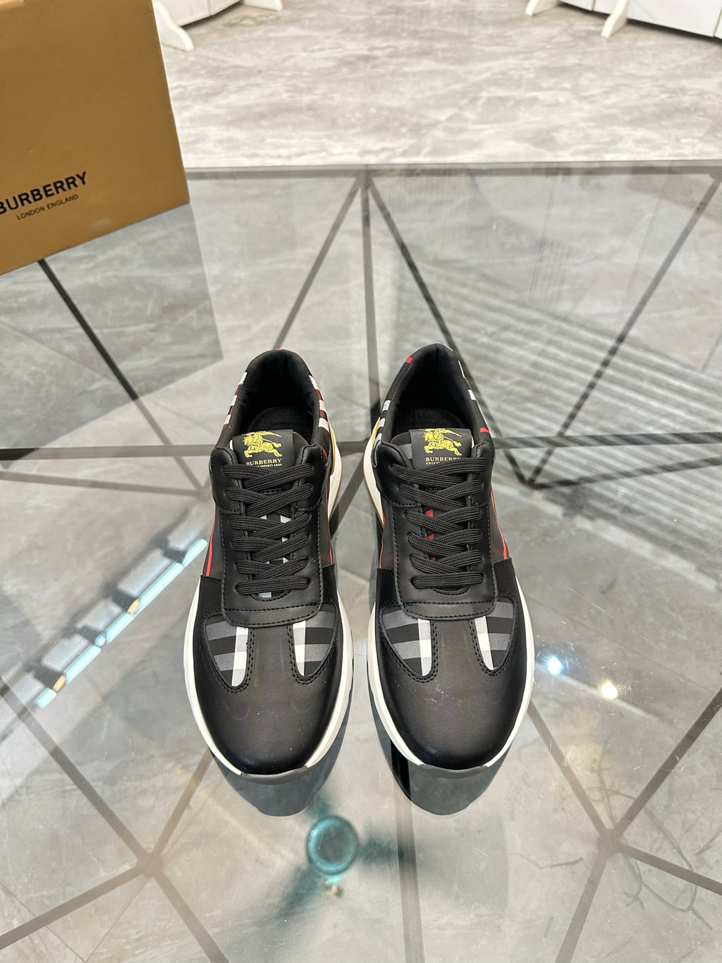Black low-top sneakers with white check panel and red stripe accents