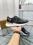 Black low-top sneaker with plaid side stripe, red line, and gum sole edge
