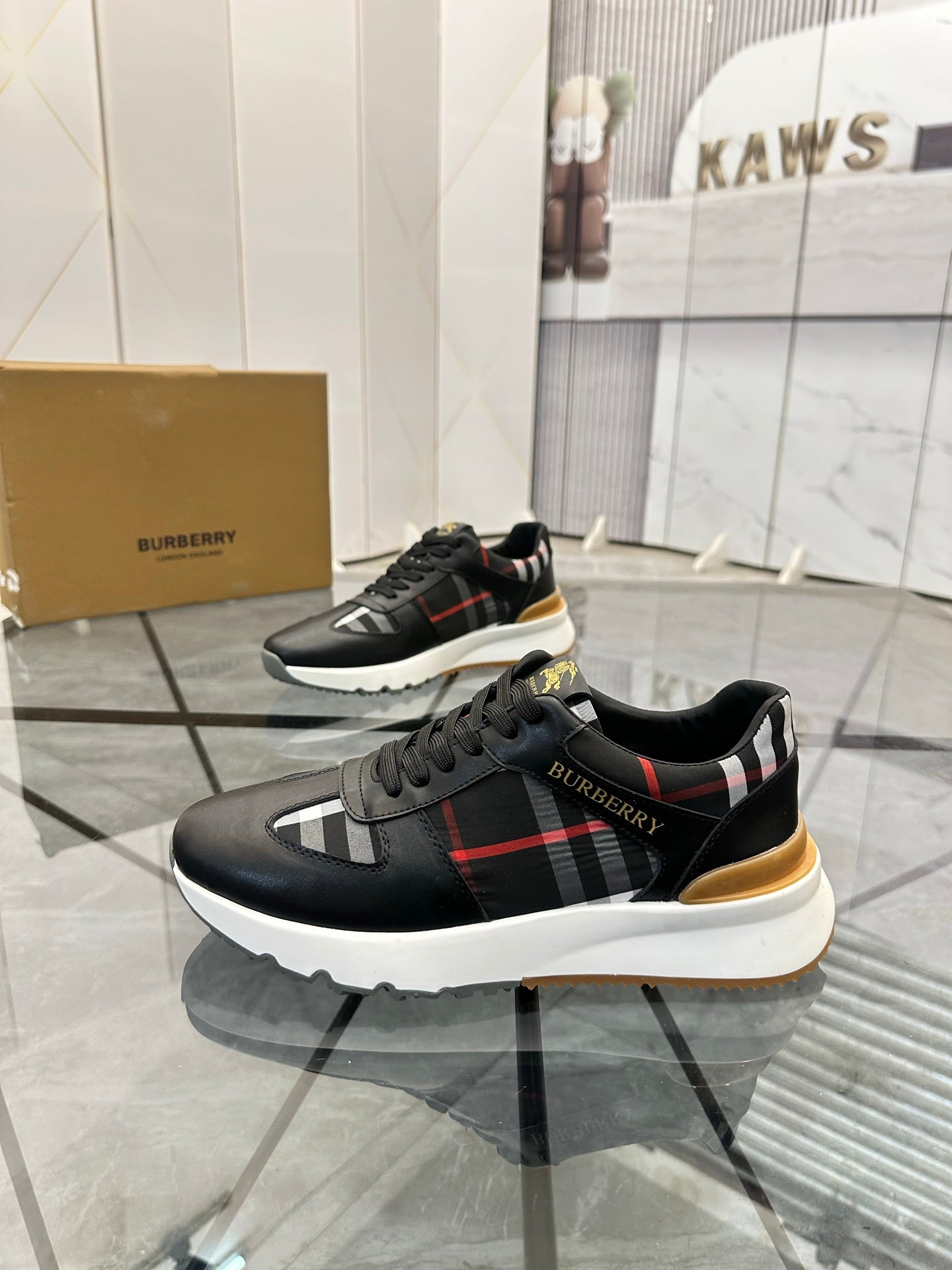 Black low-top sneakers with plaid side stripe, gum heel detail, chunky sole