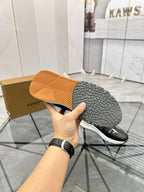 Shoe outsole view of black low-top sneakers with textured tread