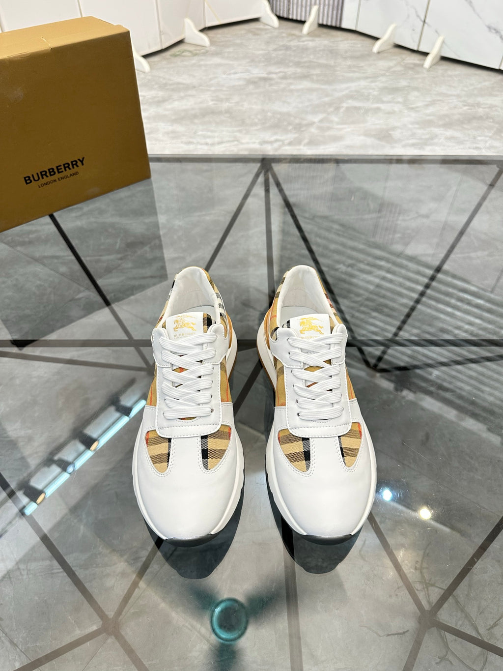 Burberry white sneakers with lace-up front, check panel accents, and gold-toned trim