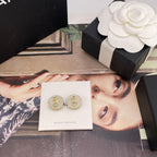 Chanel round stud earrings with pink CC logo, displayed on branded card