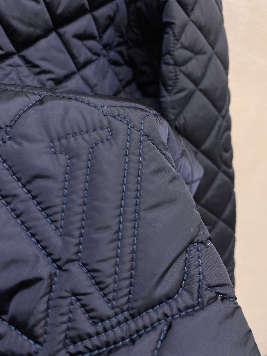 Louis Vuitton quilted jacket texture close-up, stitched diamond pattern