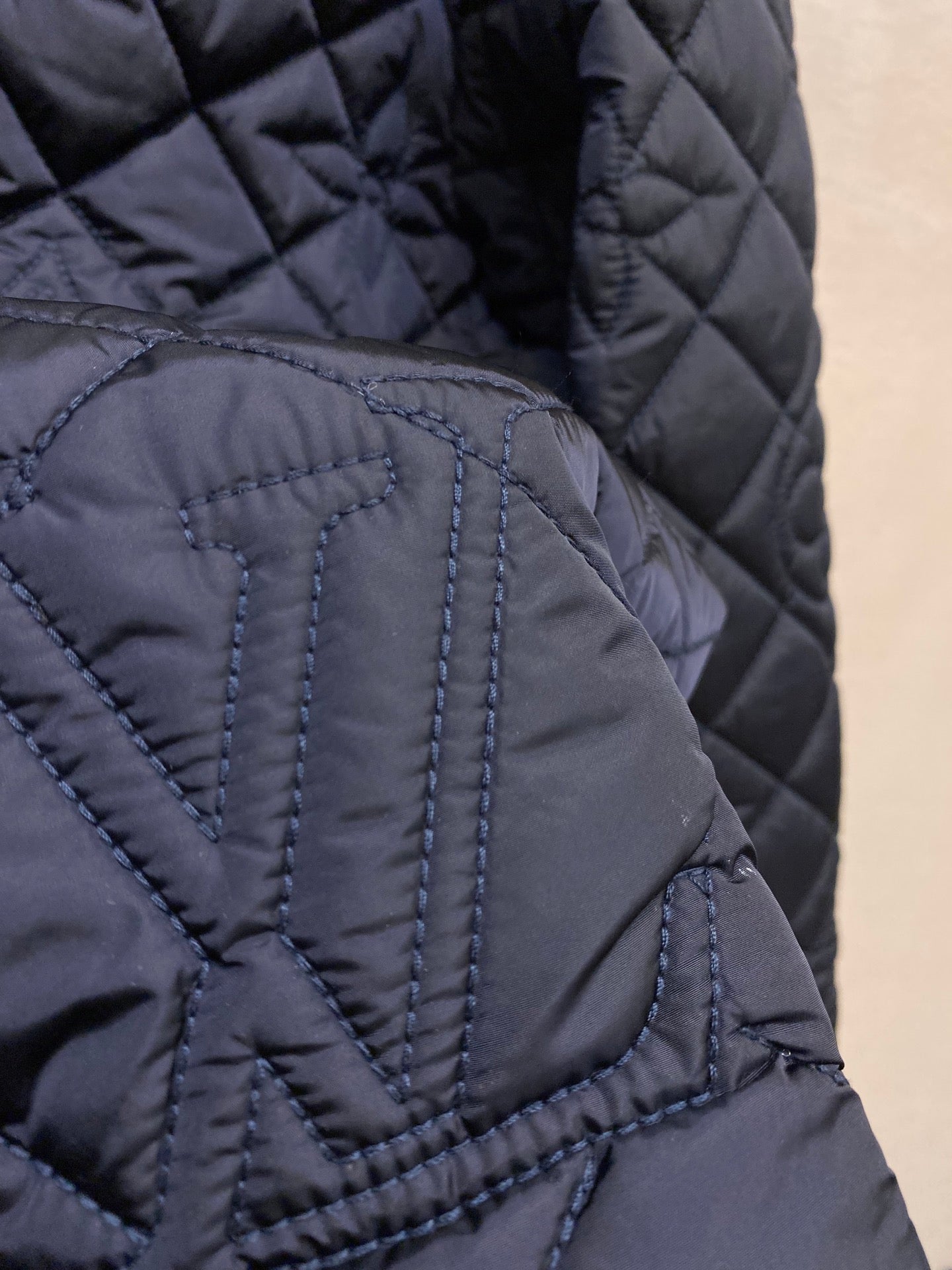 Louis Vuitton quilted jacket texture close-up, stitched diamond pattern