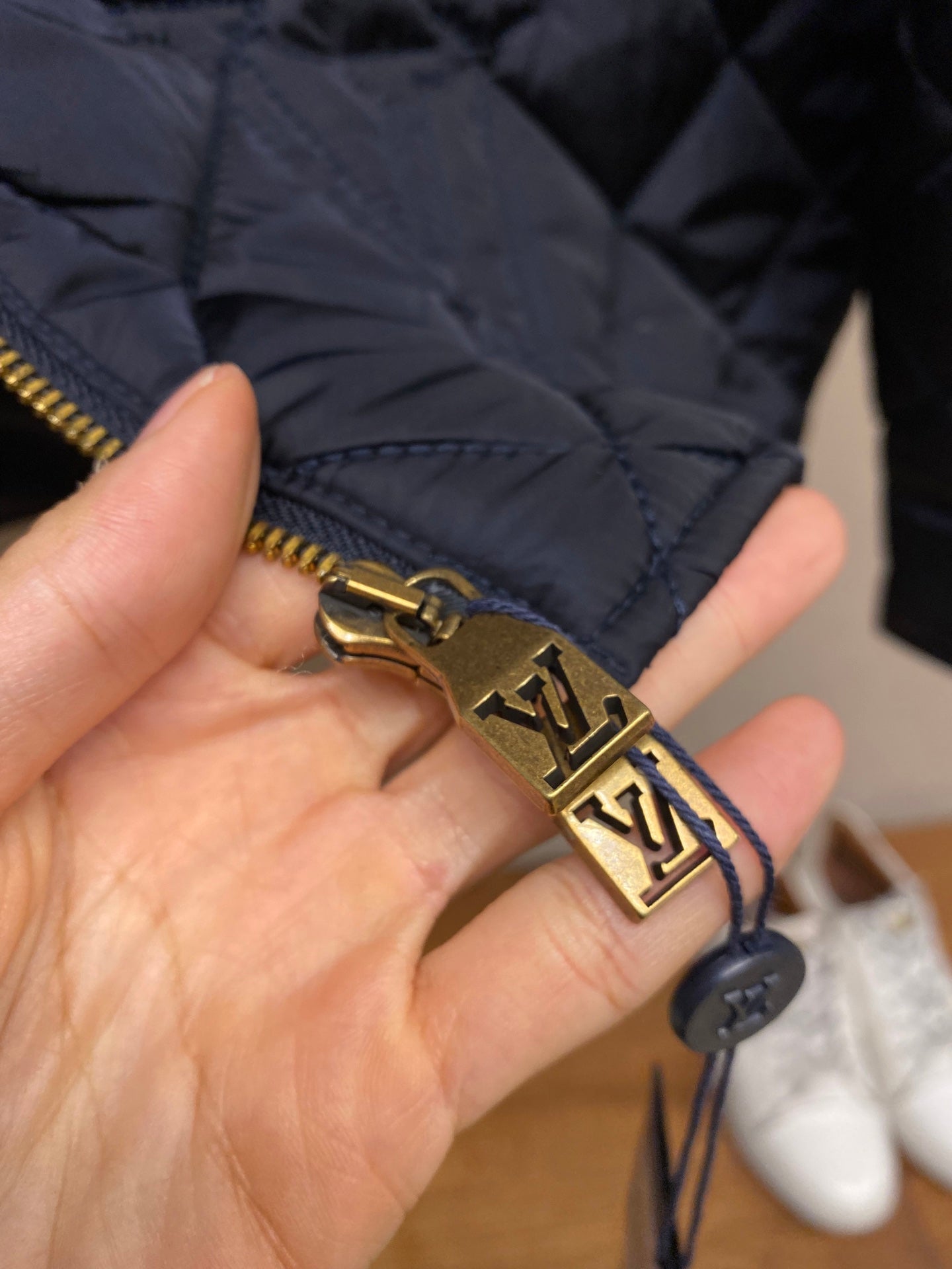 Louis Vuitton jacket zipper pull with gold-tone LV logo charm