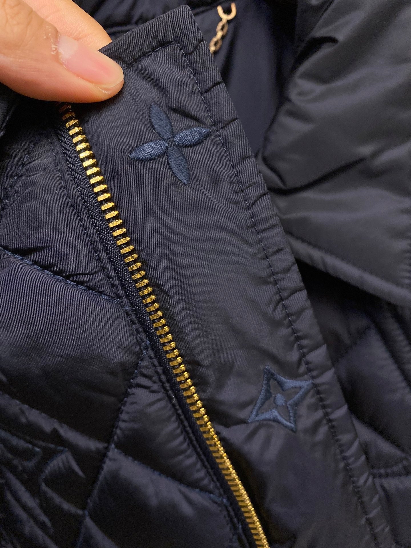 Louis Vuitton jacket detail, embroidered floral motif near gold zipper