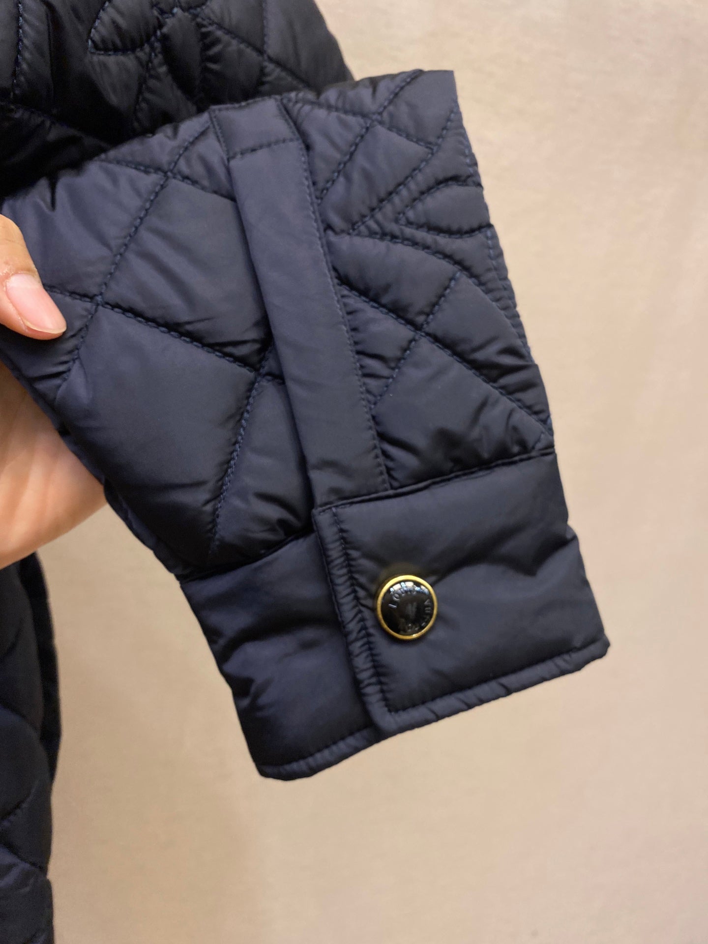 Louis Vuitton quilted jacket sleeve cuff with gold snap button detail