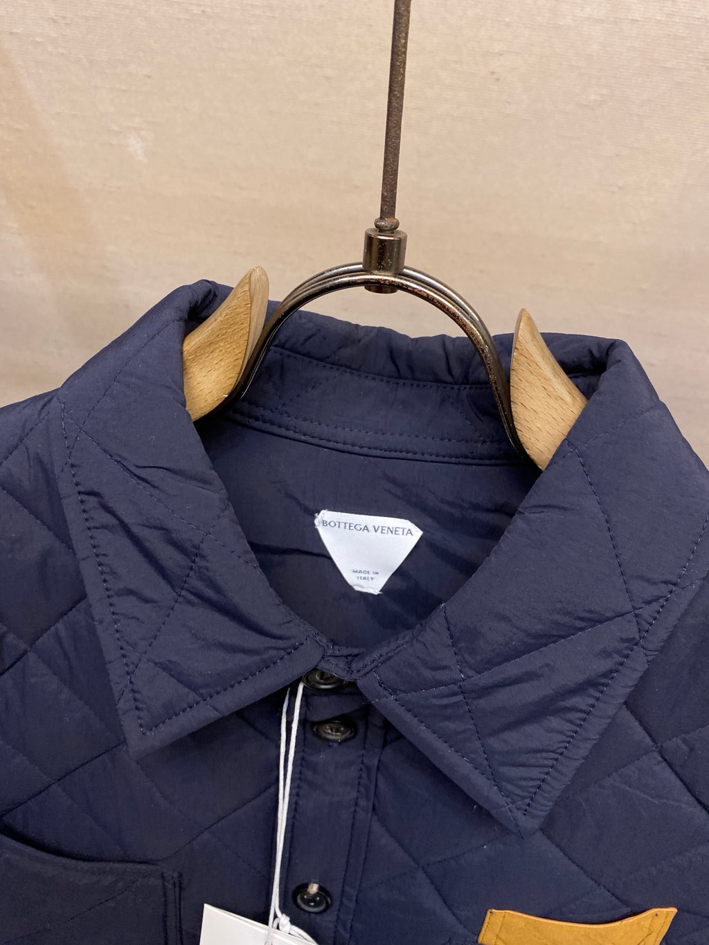 Navy quilted jacket with buttoned stand collar and inner label