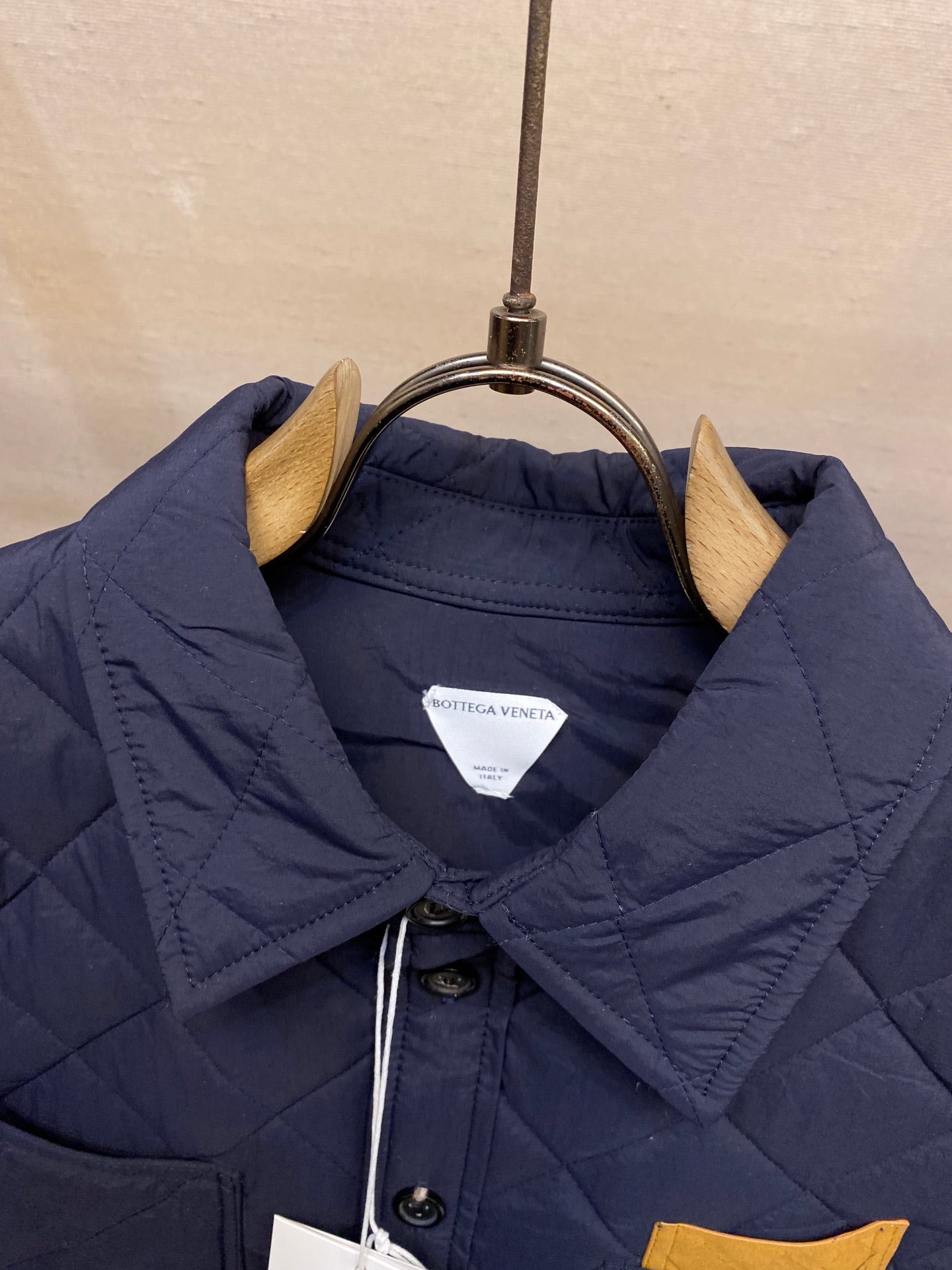 Navy quilted jacket with buttoned stand collar and inner label