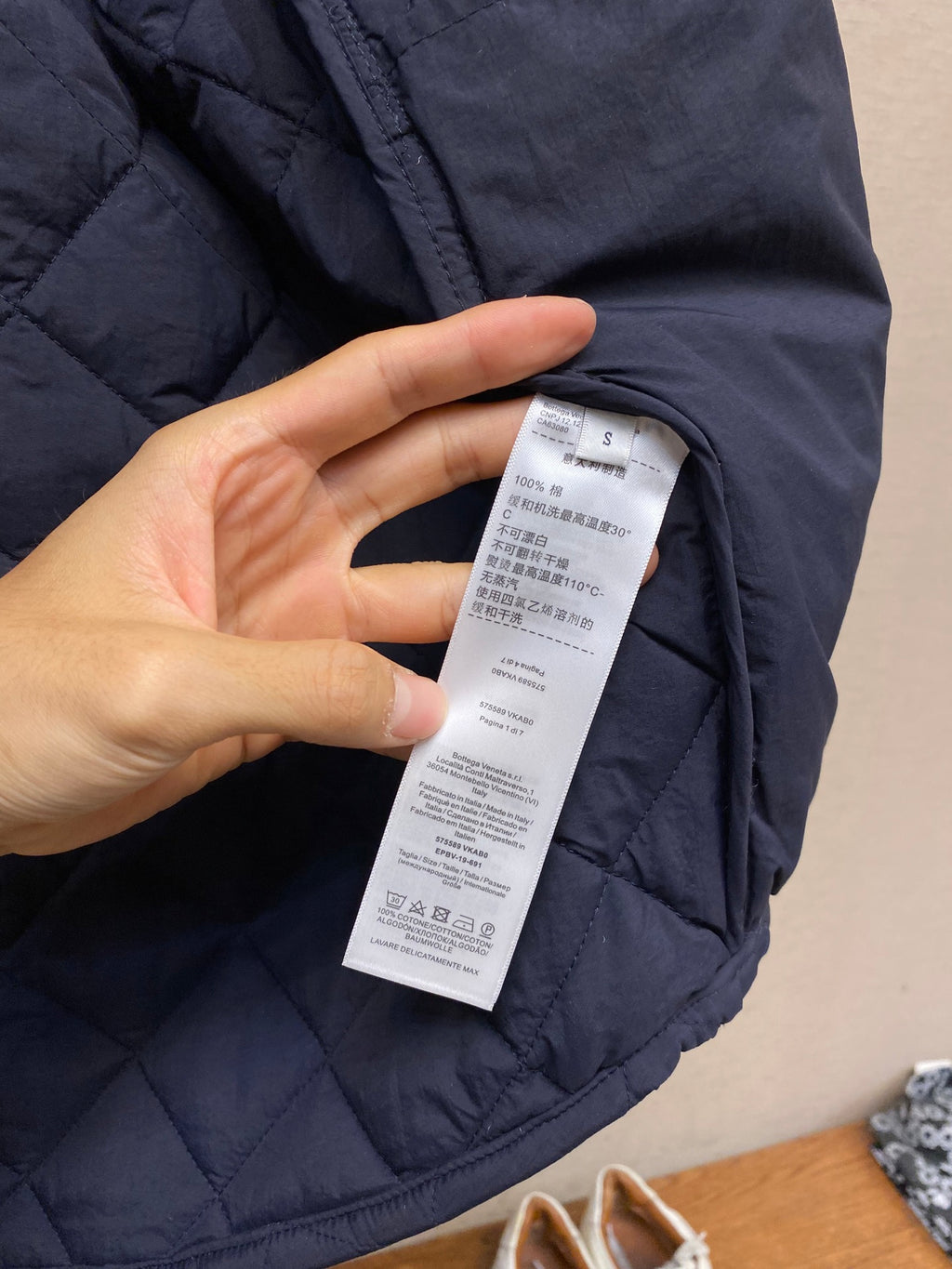 Navy quilted jacket sleeve with white size label