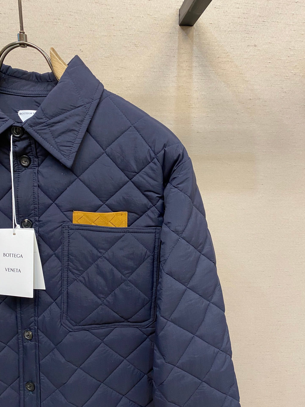 Navy quilted jacket close-up of chest pocket and button placket