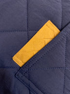 Navy quilted fabric with mustard yellow chest pocket and stitching