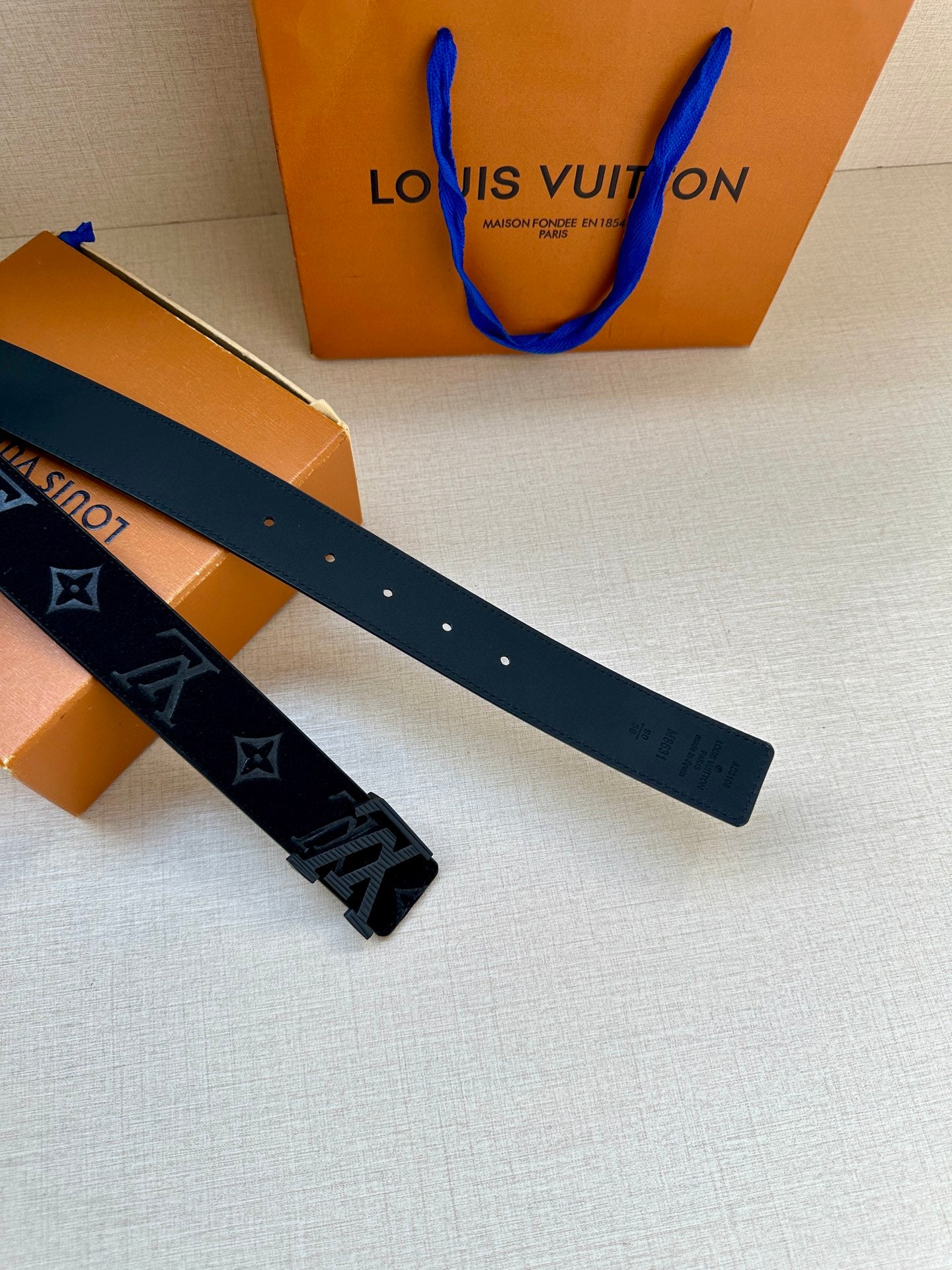 Dark navy leather belt strap with perforated holes and LV monogram star motifs