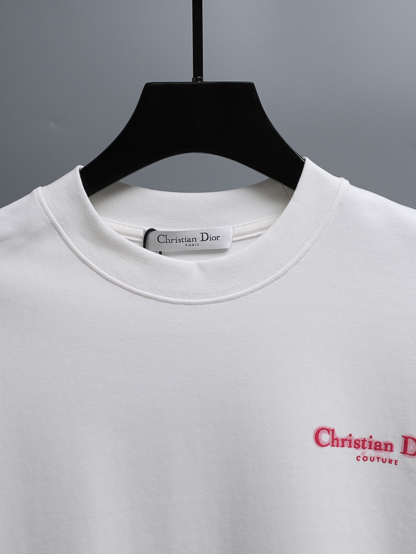 White crewneck T-shirt on hanger with small logo print at chest