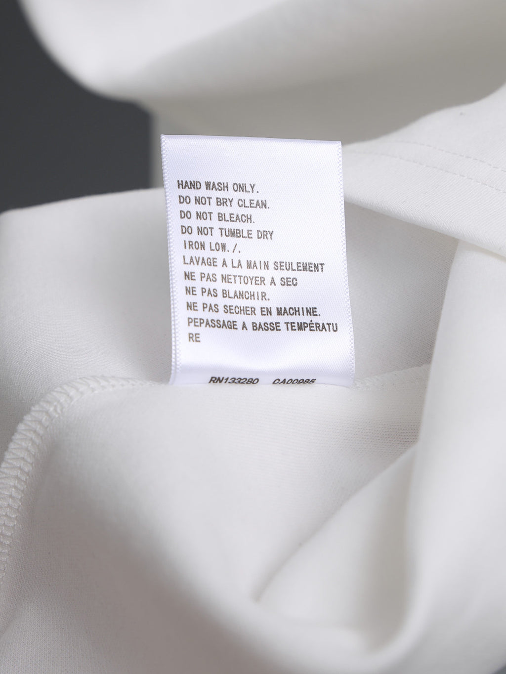 White garment care label tag at neckline