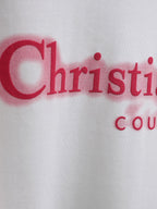 Red Christian Dior Couture logo close-up on white T-shirt fabric