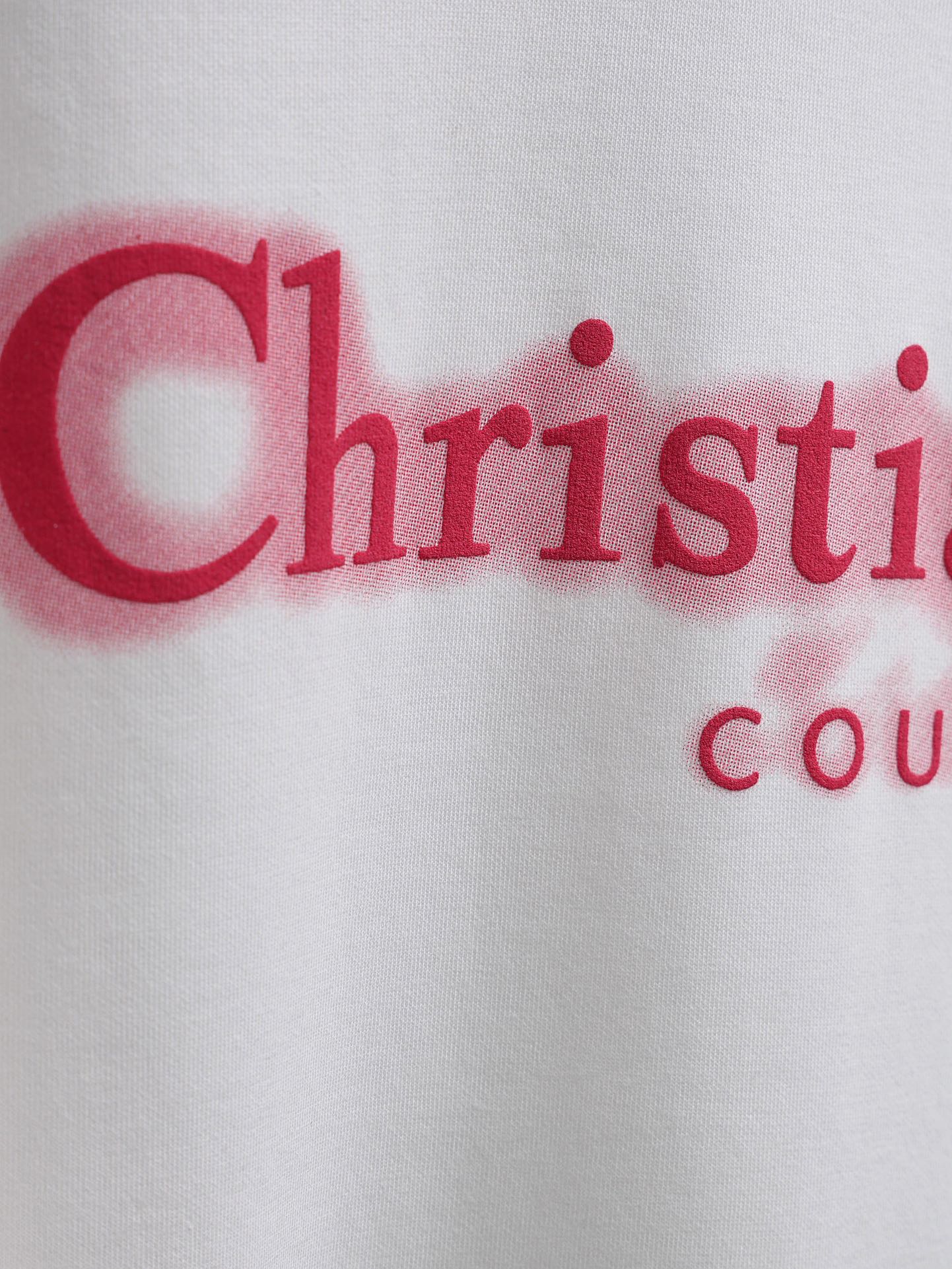 Red Christian Dior Couture logo close-up on white T-shirt fabric
