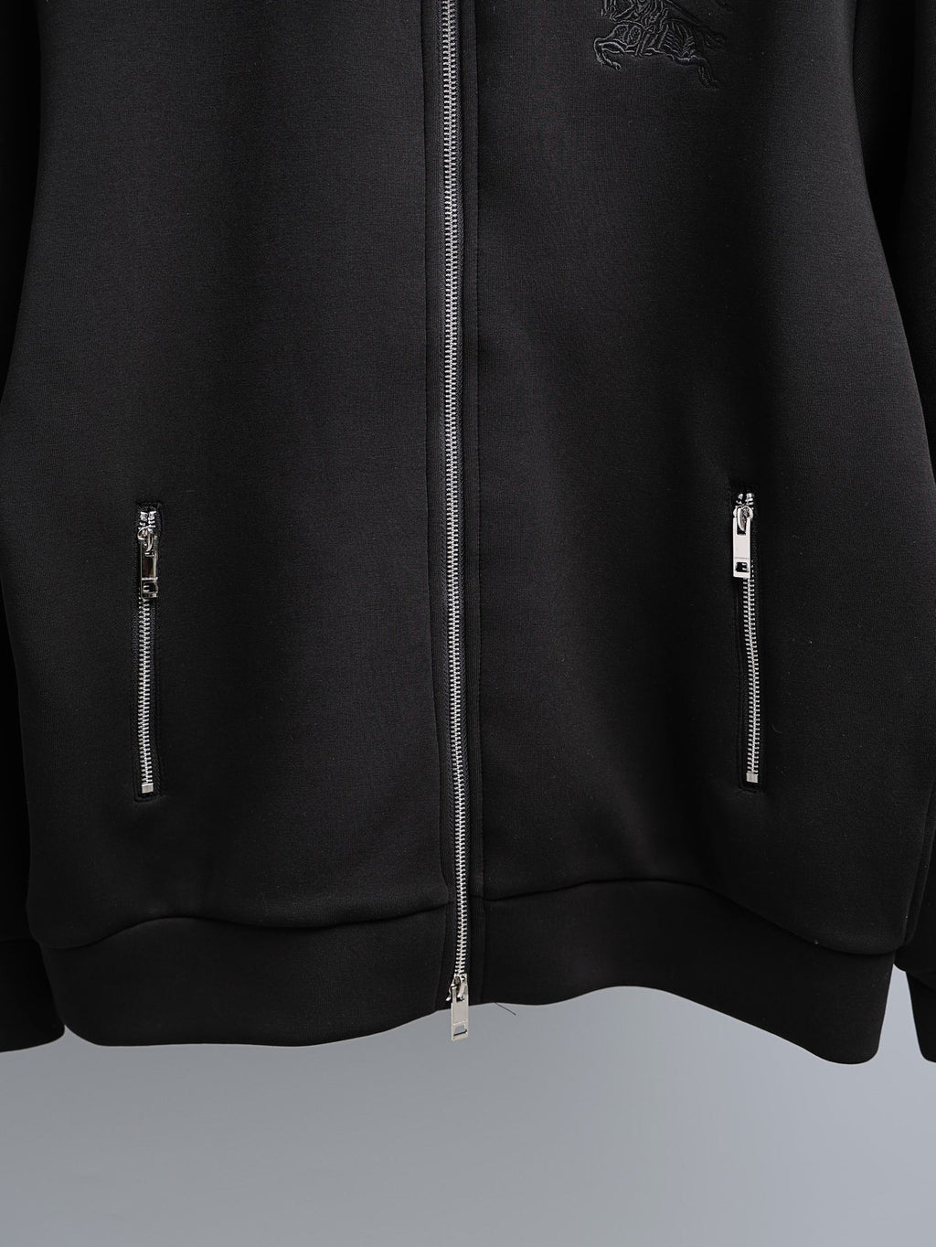 Black zip-up hoodie with center silver zipper and two side zipper details