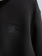 Black zip-up hoodie with embossed crest logo on chest