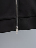Black zip-up hoodie close-up of silver zipper and pull