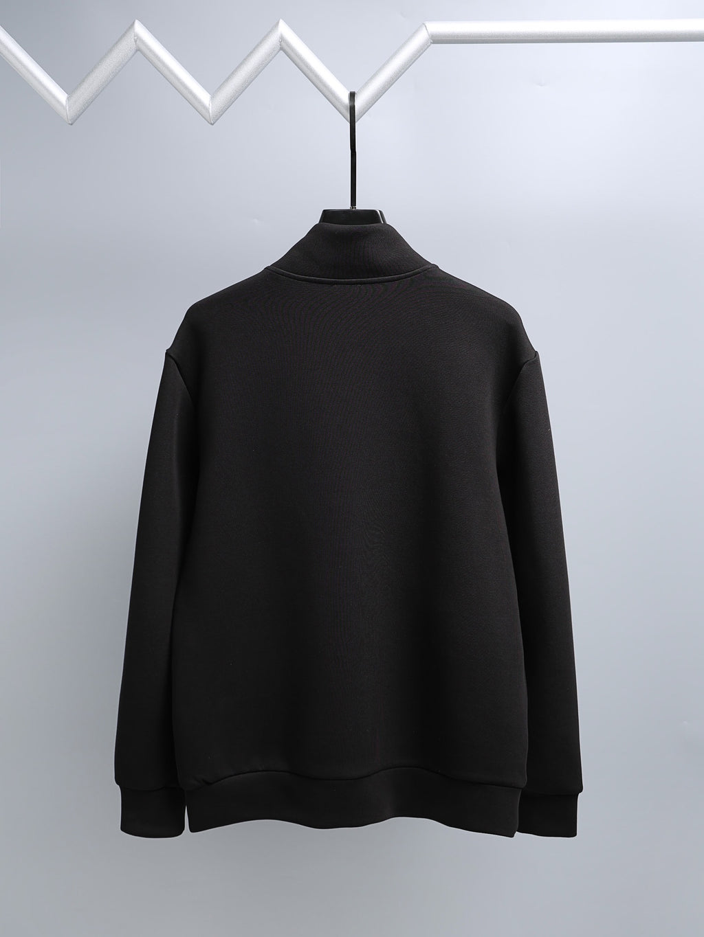 Black long-sleeve mock-neck top, full front view on hanger
