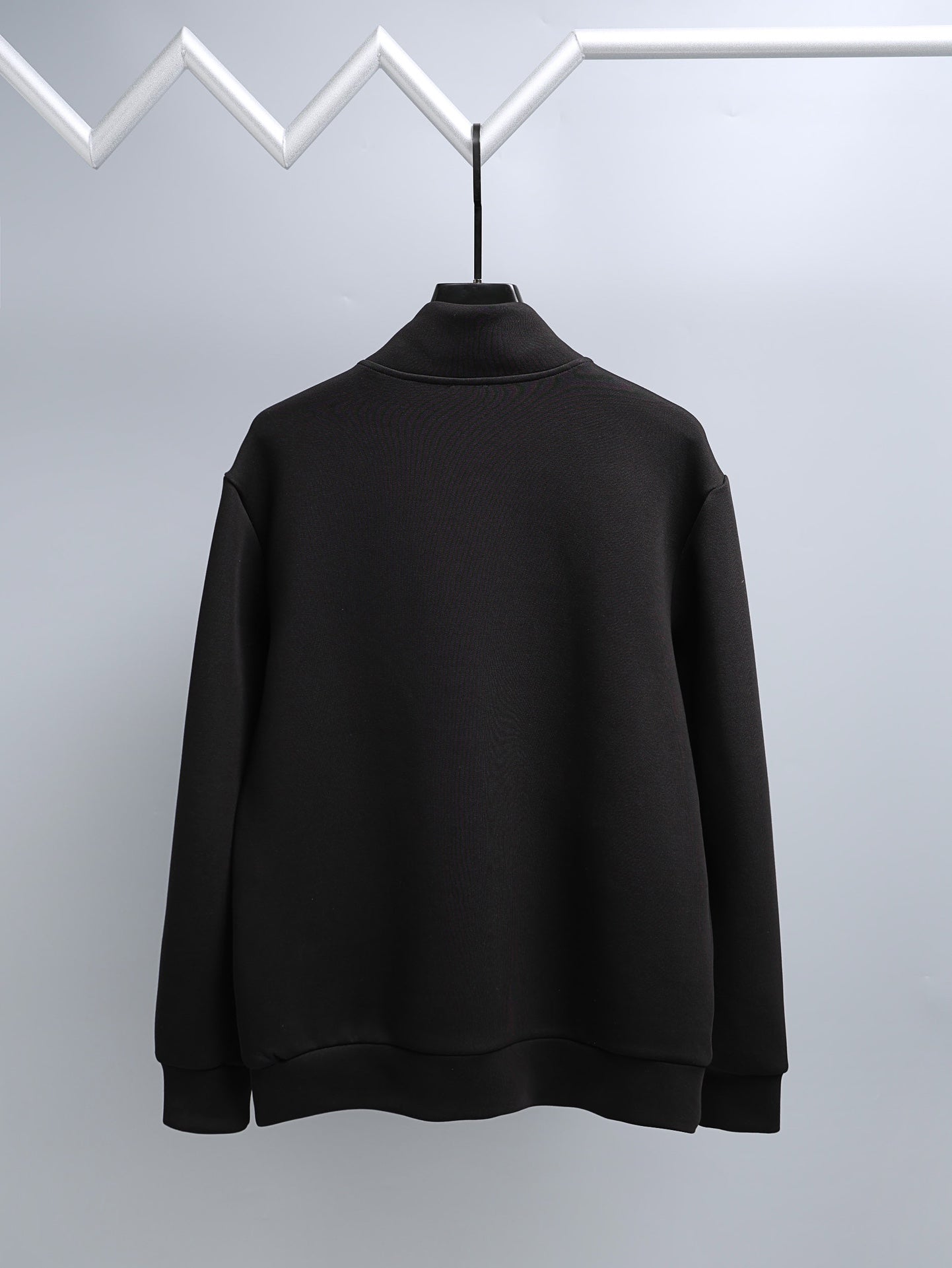 Black long-sleeve mock-neck top, full front view on hanger