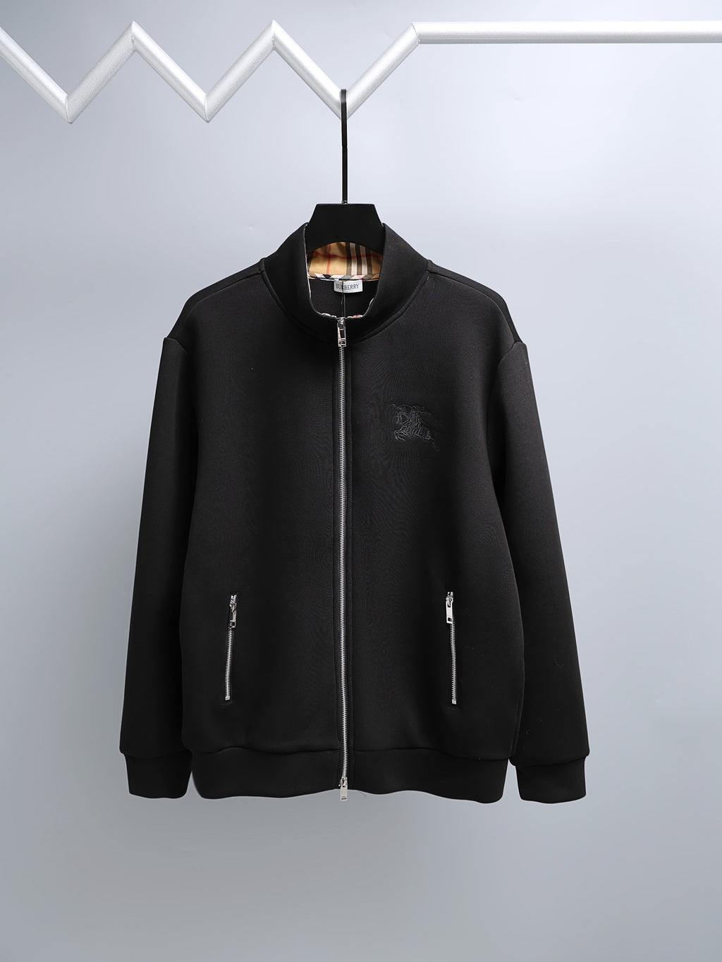 Black zip-up hoodie with raised collar and silver front zipper