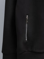 Black zip-up hoodie sleeve with small silver zipper detail