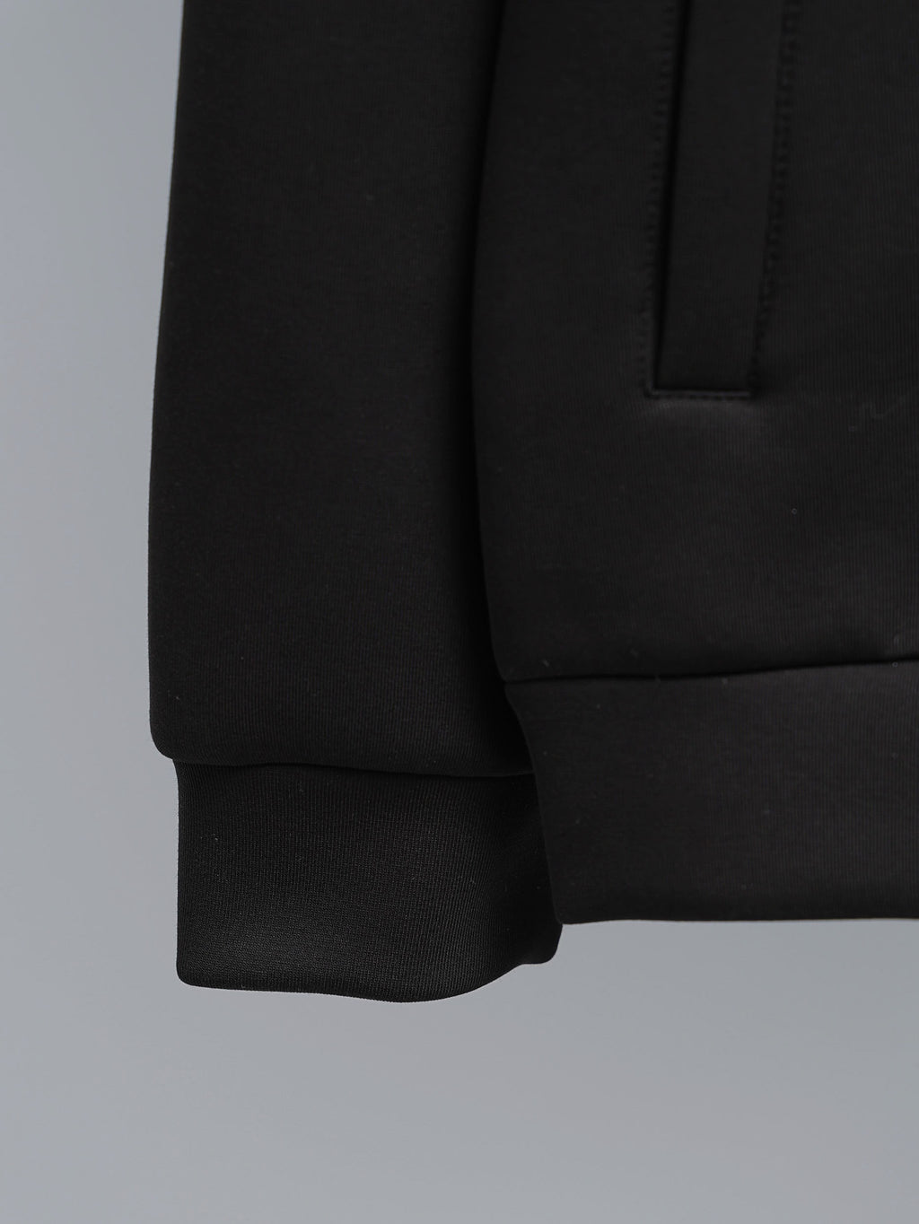 Black jacket sleeve with ribbed cuff and front pocket detail