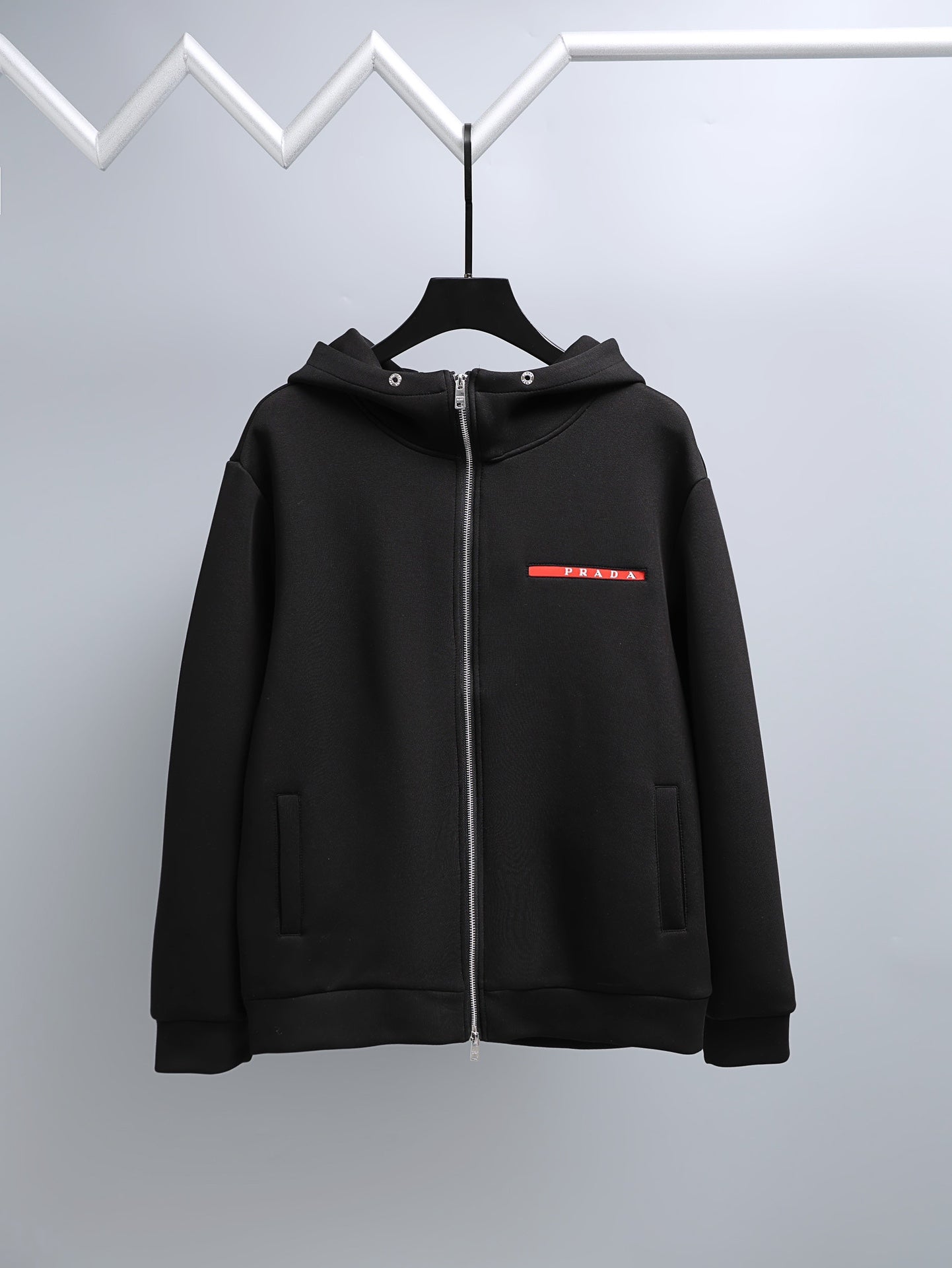 Black zip-up hooded jacket with Prada logo on chest