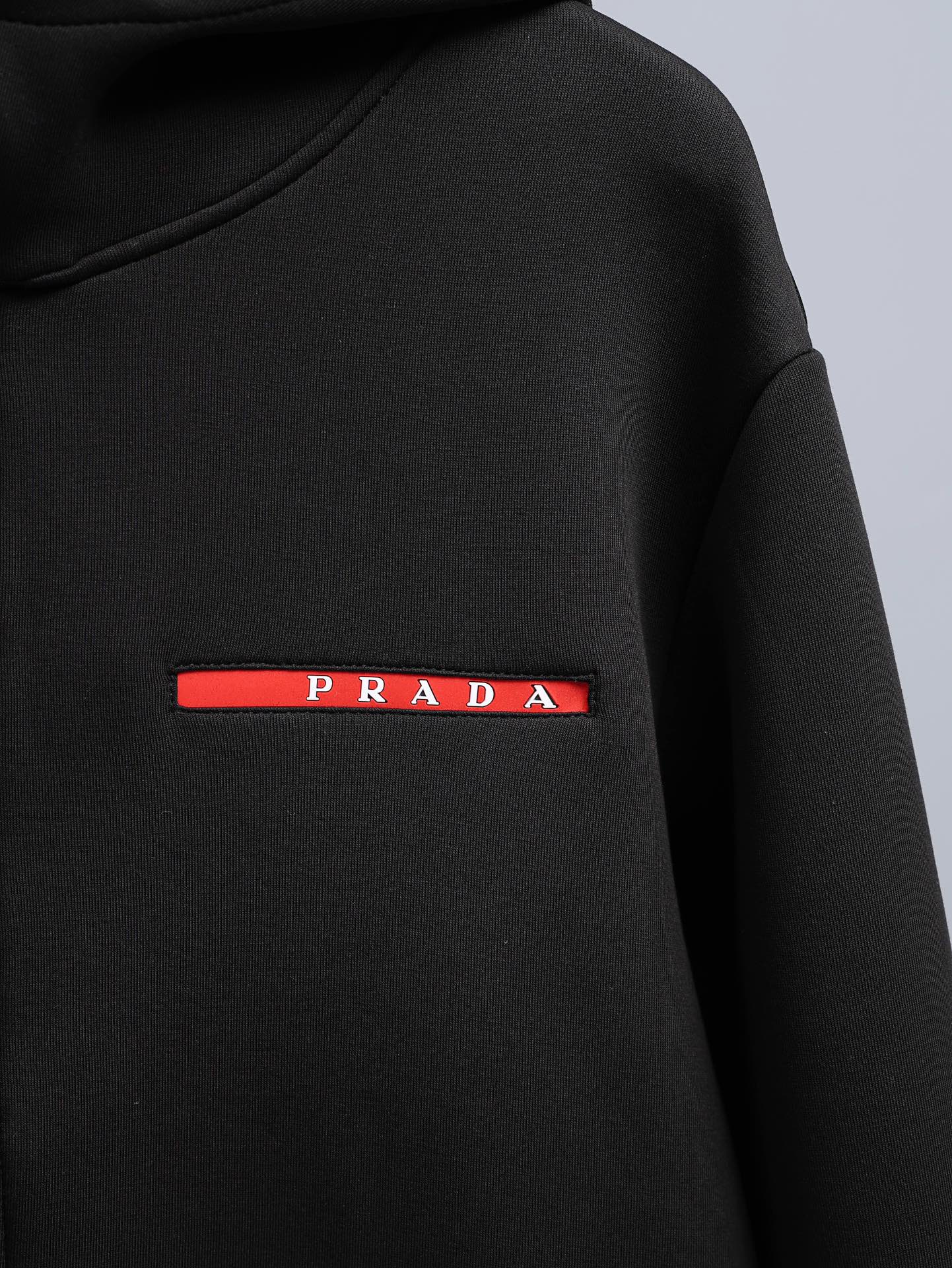Black zip-up hooded jacket with red PRADA logo bar