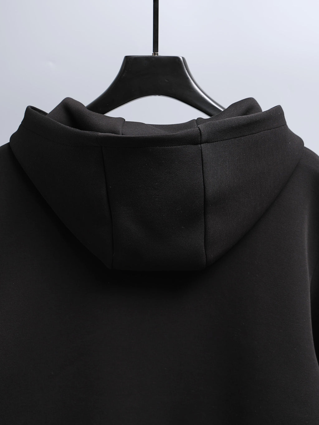 Black zip-up hooded jacket with hood and back seam