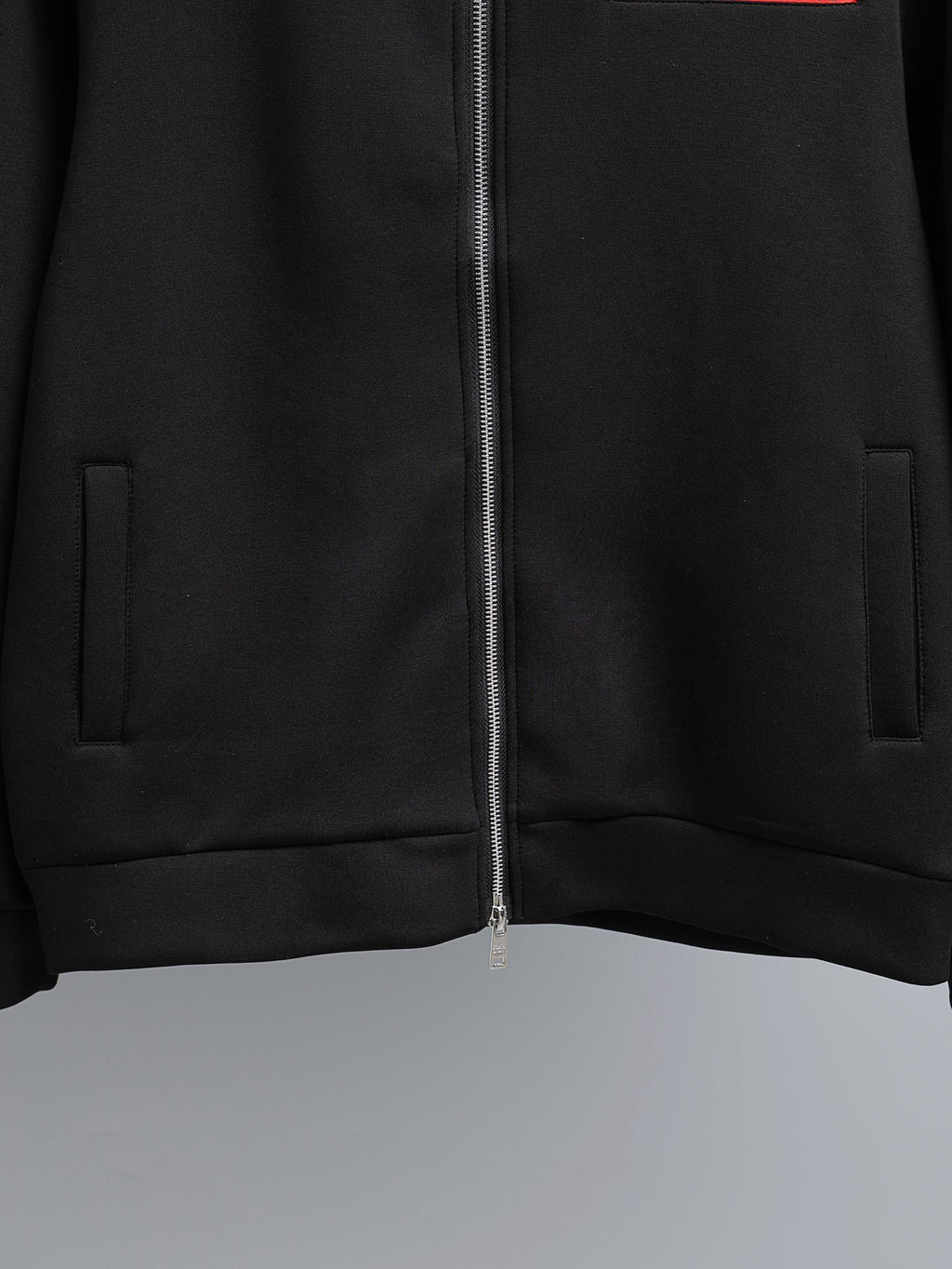 Black zip-up jacket with central zipper and side welt pockets