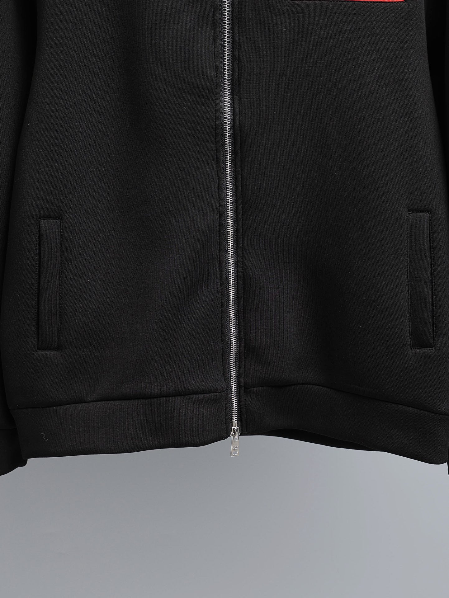 Black zip-up jacket with central zipper and side welt pockets