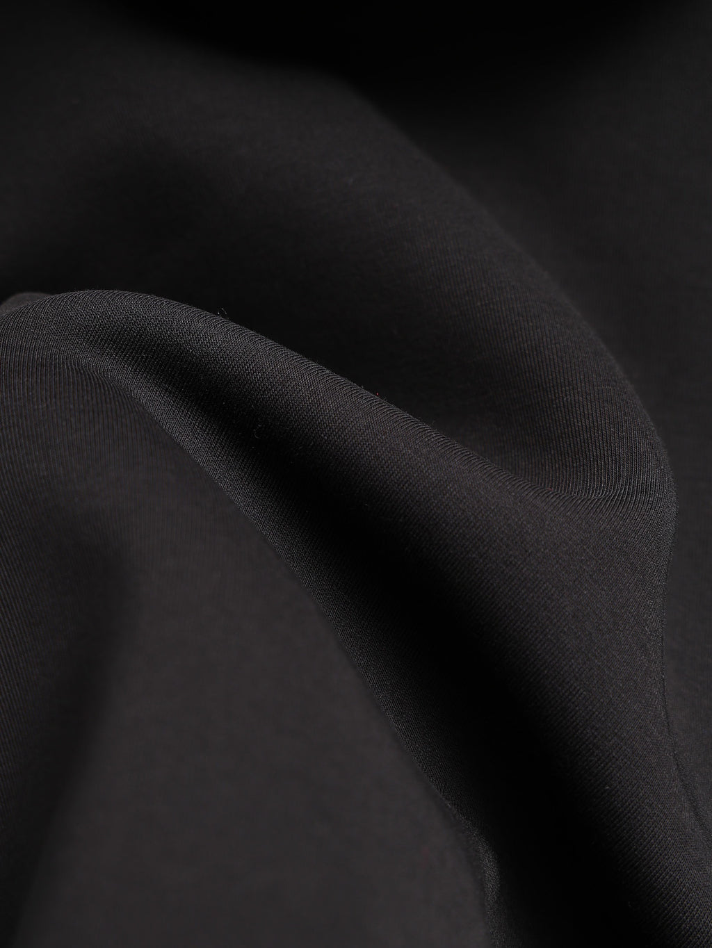 Black jacket fabric close-up with fine grain texture