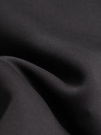 Black jacket fabric close-up with smooth, woven texture