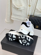 Chanel white sneakers on top view with black sole and logo badge on heel