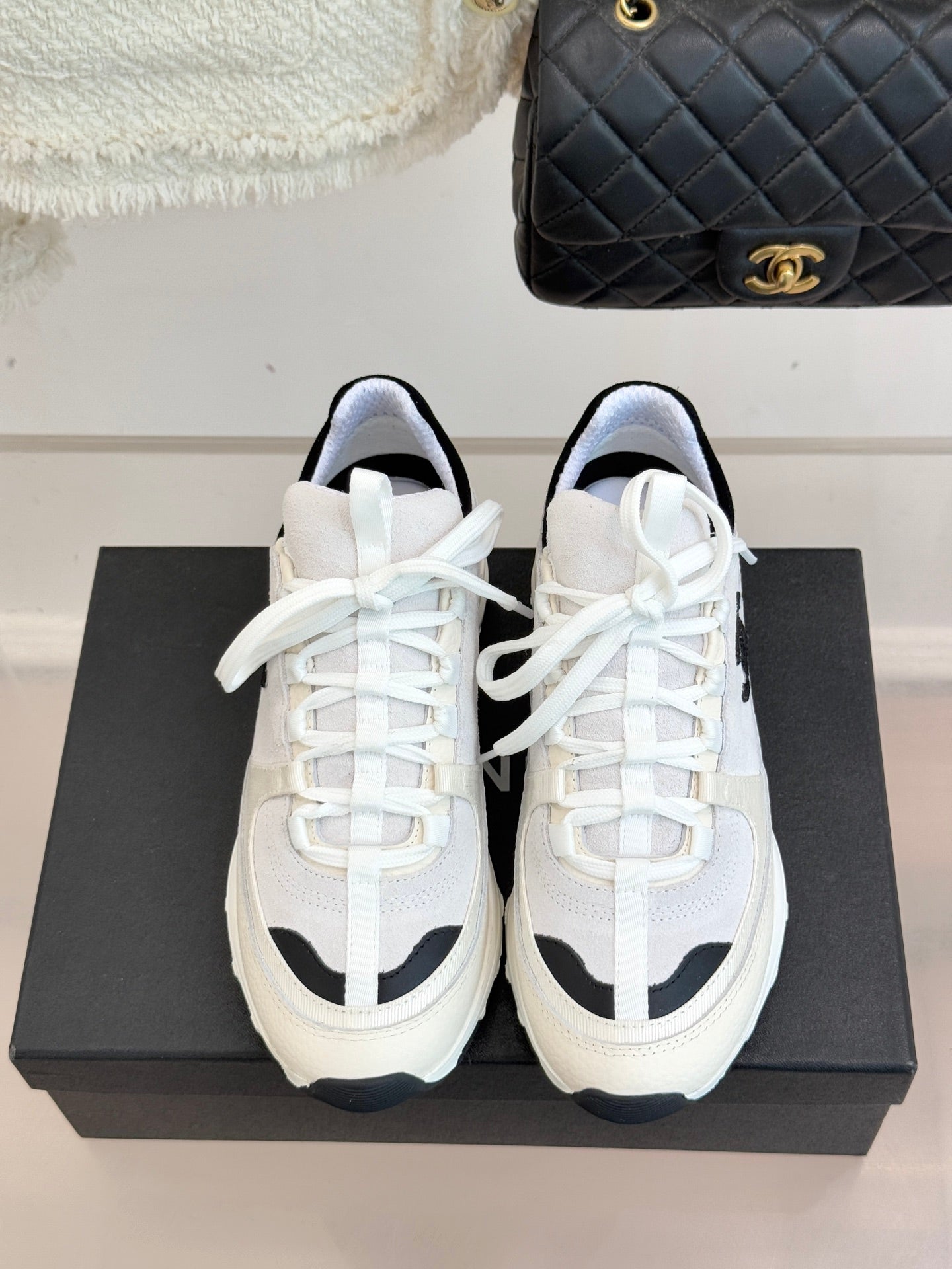 Chanel white lace-up sneakers with black-trim details and cushioned tongue