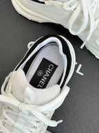 Chanel sneaker inside view showing “CHANEL” on tongue label and white laces