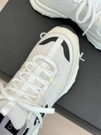 Chanel sneaker close-up with white laces and black heel trim on the side