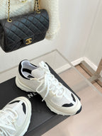 Chanel white sneakers with black side inserts and white laces on black box