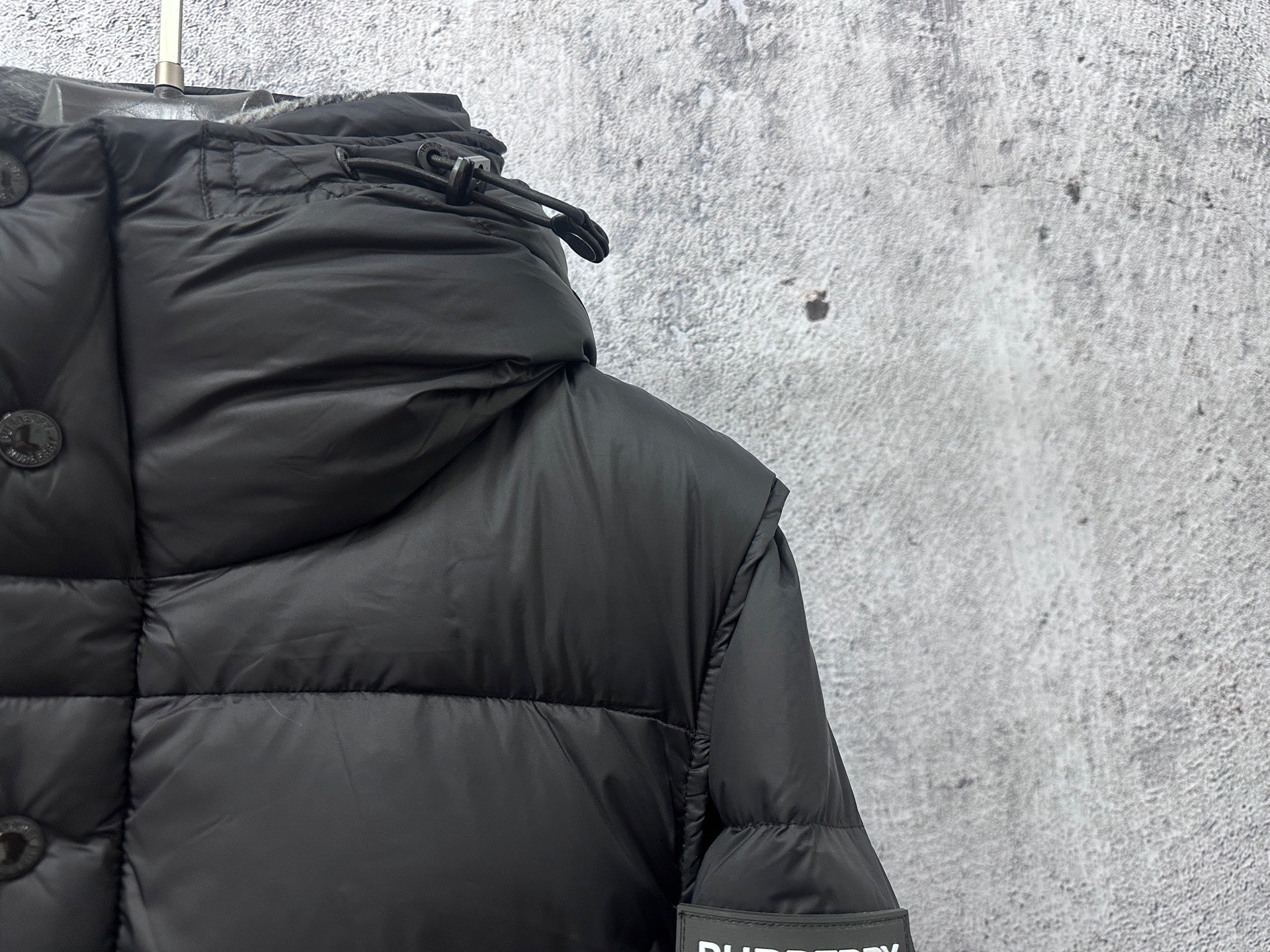 Quilted puffer jacket hood area and shoulder seam detail, dark fabric