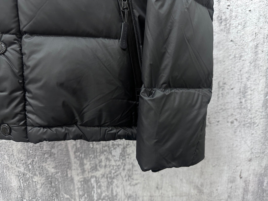 Long puffer jacket side view with zipper, buttons, and dark front pocket