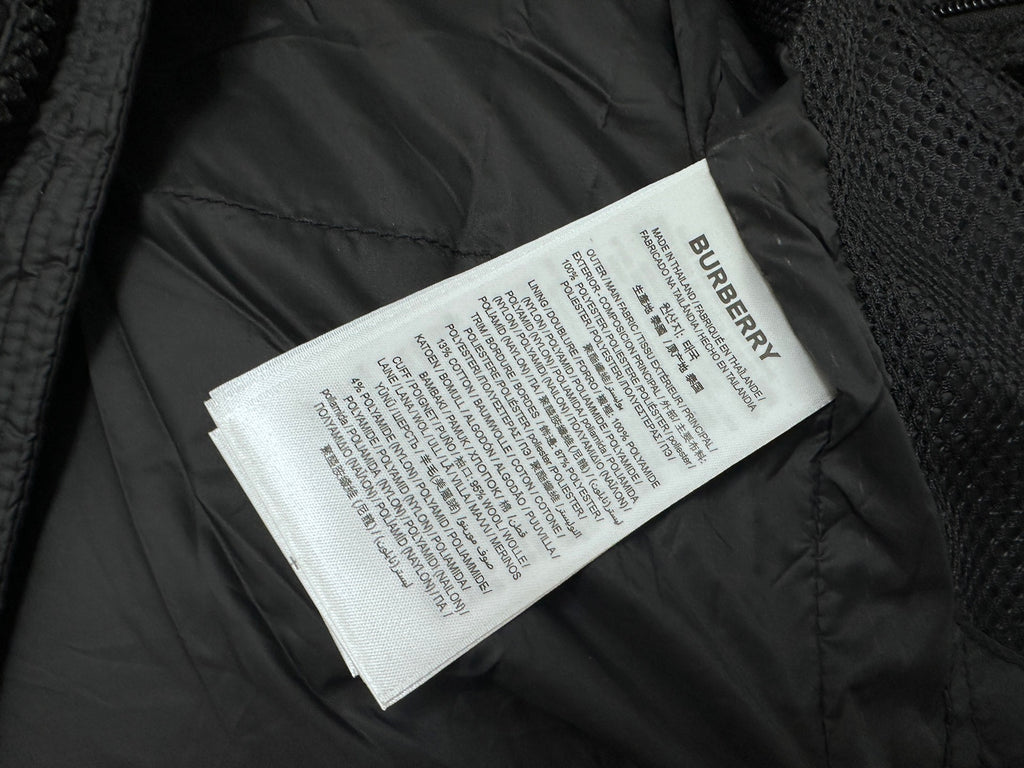 Long puffer jacket interior with Burberry care label on dark fabric