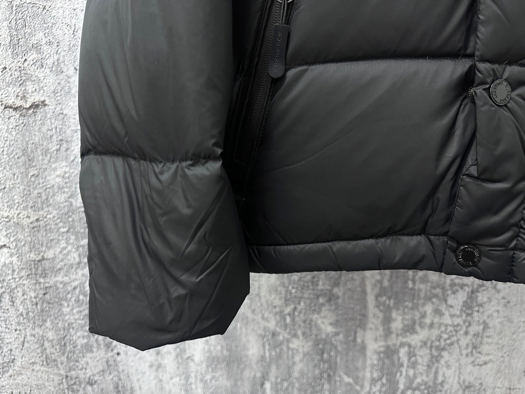 Long puffer jacket sleeve and hem with quilting and button cuff detail