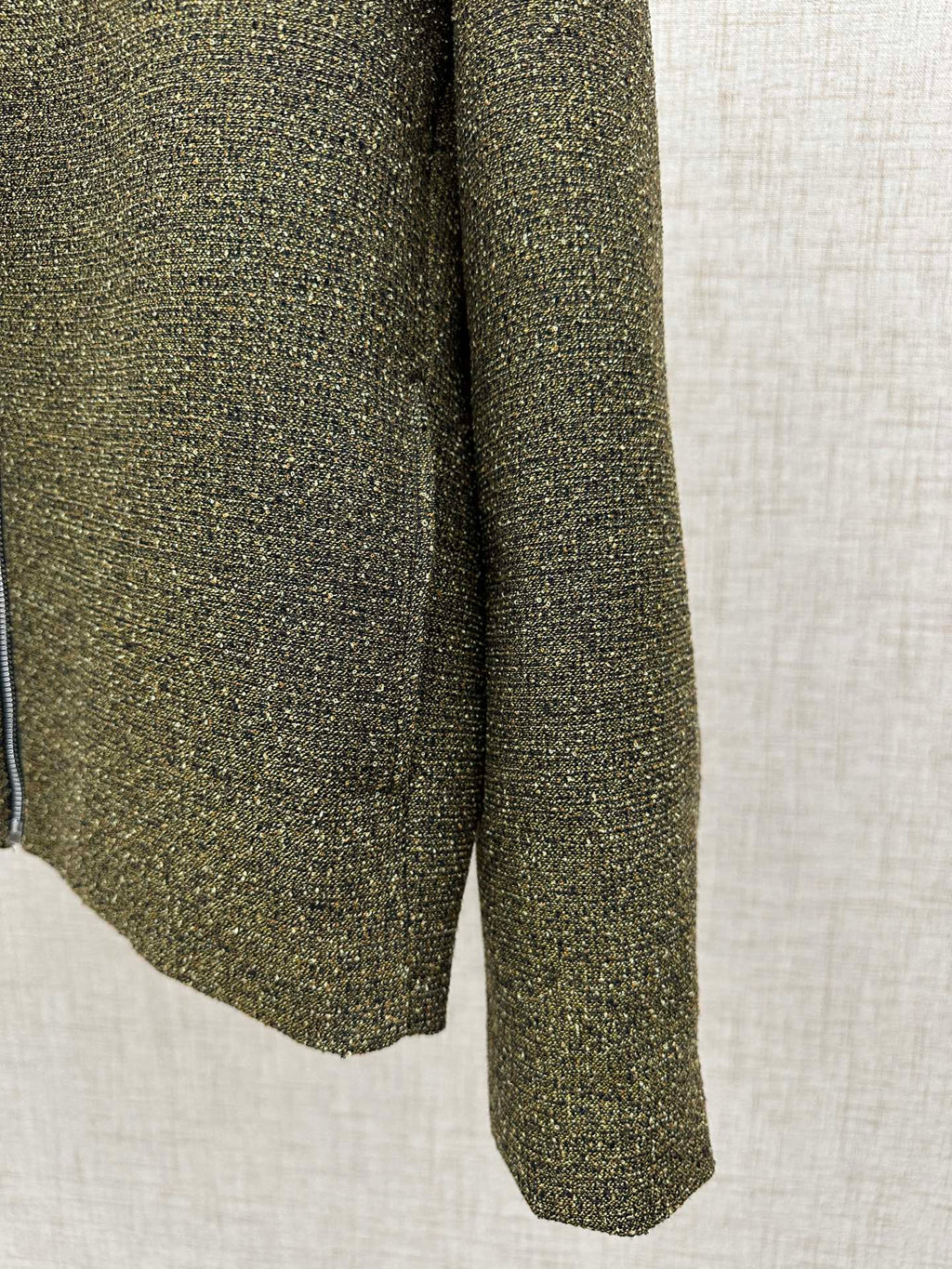 Olive textured jacket hem and side seam with flared silhouette