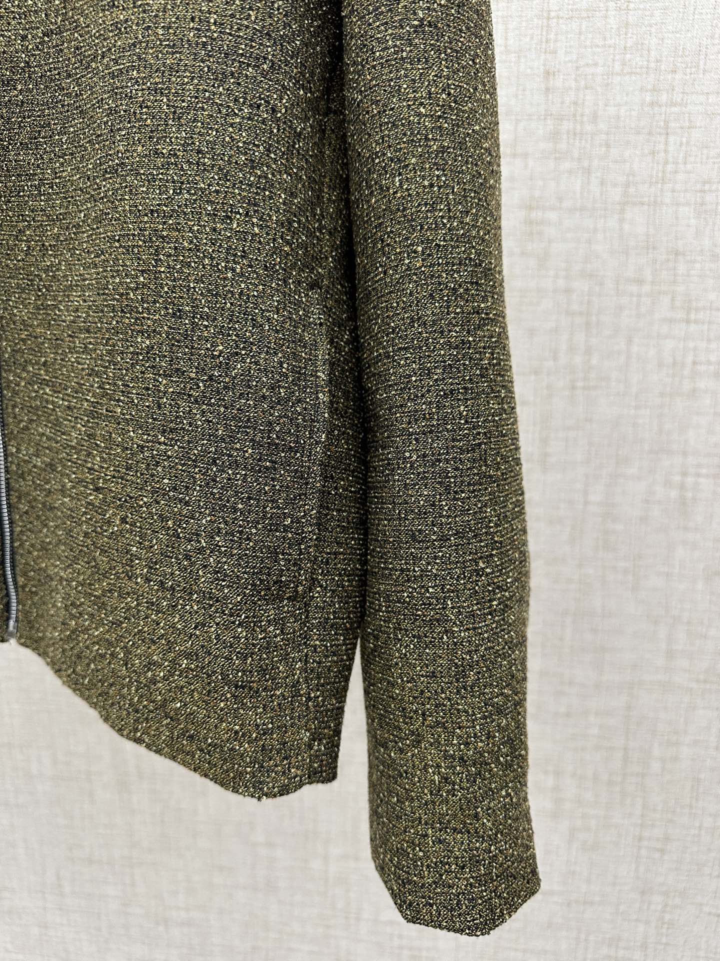 Olive textured jacket hem and side seam with flared silhouette
