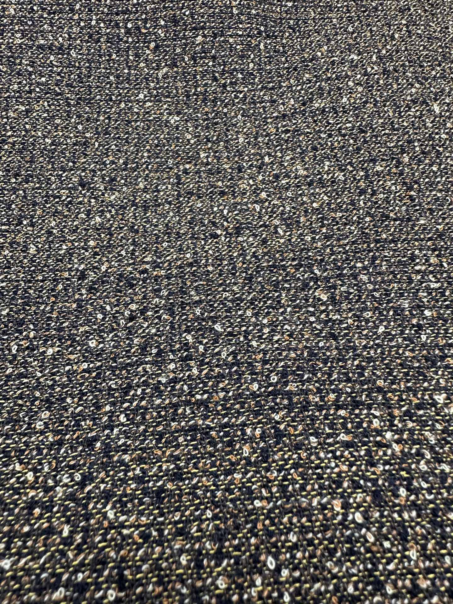 Close-up of olive and dark speckled woven fabric texture