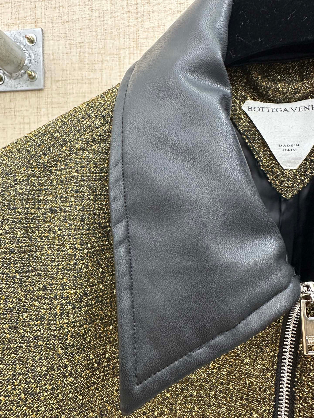 Dark blue inner collar panel and front zipper on olive textured jacket