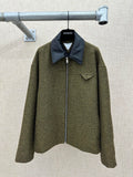 Olive textured jacket with dark blue pointed collar and front zipper closure